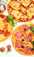 Different types of italian pizza on light background.