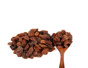 A spoonful of raisins next to a bunch of sweet raisins on a white background.