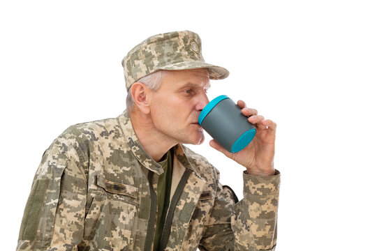 Portrait of old defender drinks a beveridge from a plastic thermosisolated cup.isolated on white background. Soldier in uniform posing in studio.