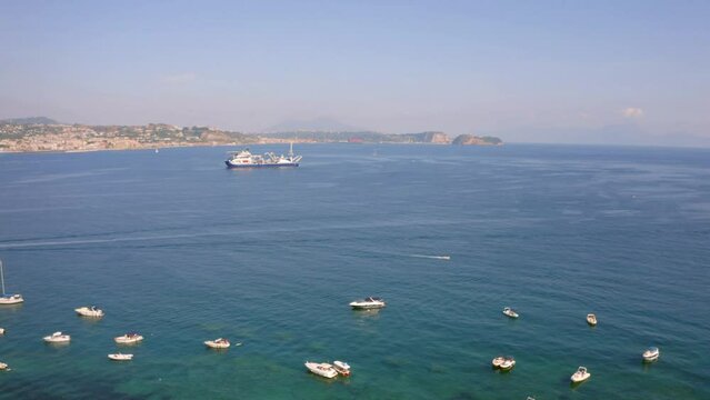 4k drone forward video (Ultra High Definition) of tourist yachts near Bacoli town, Italy, Europe. Adorable morning seascape of Mediterranean sea. Traveling concept background.