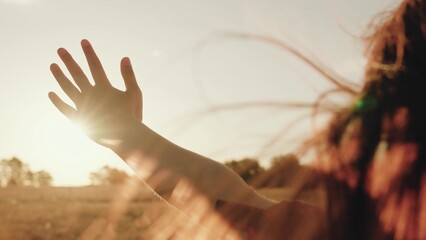 Woman tourist puts hand out of driving car window on rural road at sunset light - Powered by Adobe