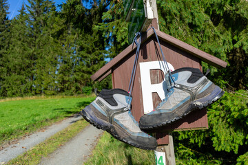 a pair of walking boots on a sign on the Rennsteig in the Thuringian Forest - obrazy, fototapety, plakaty