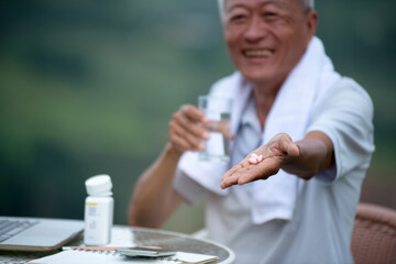 Asian old man showing daily pills for good health, concept of healthy living in the elderly, selective focus