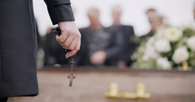 Funeral, religion and hands with rosary for memorial service, death ceremony and obituary sermon. Christianity, burial and closeup of pastor or priest with religious symbol for gospel, faith and loss