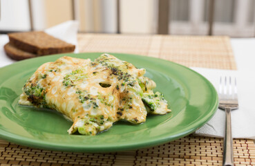 Wholesome breakfast. omelet with broccoli on green plate
