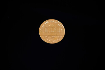 Vienna Philharmonic 25 Euro.
Gold coin on a black background.