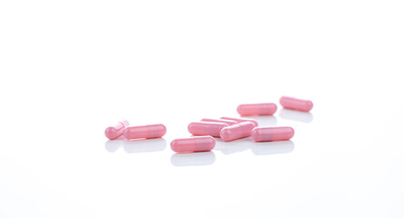 Obraz na płótnie Canvas Pink capsule pills on white background. Pharmaceutical industry. Vitamins, minerals, and supplements concept. Pharmacy products. Pharmaceutical medicine. Prescription drugs. Healthcare and medicine.