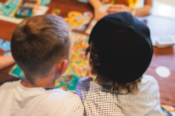 Process of playing board game and having fun with friends and family indoors, board game concept, group of kids children play board games at the table, roll the dice