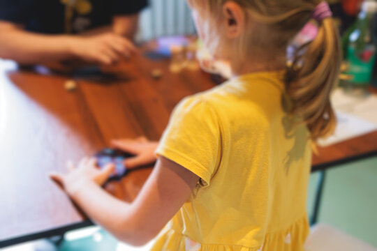 Process of playing board game and having fun with friends and family indoors, board game concept, group of kids children play board games at the table, roll the dice