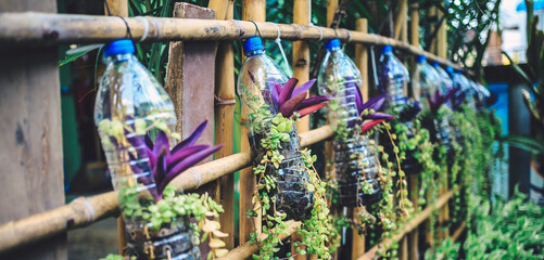 Fototapeta na wymiar Creative ideas for making plant holders from recycled plastic bottles. These can be used to decorate your garden or home while reducing packaging waste.