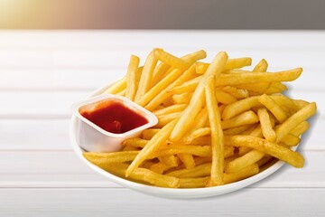 plate of hot tasty french fries with red ketchup