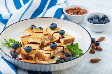 Breakfast with toasts , blueberries, almonds  and  coffee in  white and blue  tableware clouse up