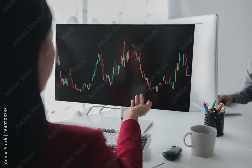 Wall mural asian woman looking at stock market graph screen, stock market businessman analyzing stock market ri