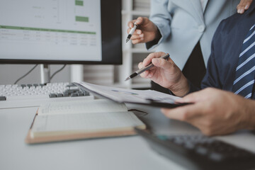 Two people looking at datasheets of marketing and sales results, analysis of business results jointly between executives, department heads and employees to brainstorm company sales management.