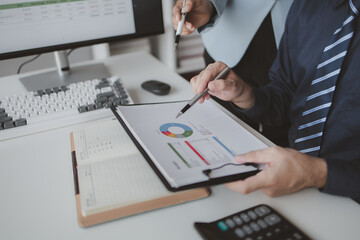 Two people looking at datasheets of marketing and sales results, analysis of business results jointly between executives, department heads and employees to brainstorm company sales management.