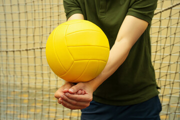 Young man and blank yellow volleyball ball