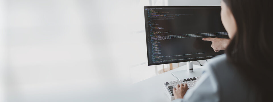 Two programmers looking at computer screen, programmer design custom computer programming, programming code and website. Computer programming design concepts.