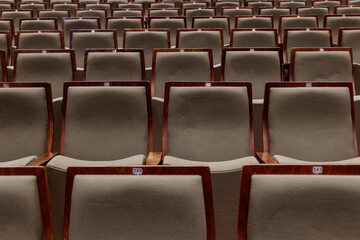 Interior view, row of vintage modern wooden seat in theater without people. 