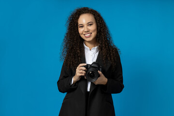 A girl in a black suit with a camera