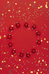 Christmas composition. Christmas round frame made of toys on red background. Little shining stars. Flat Lay, Copy Space.