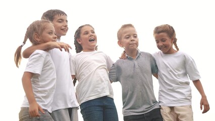 Obraz premium a group of children jumping in the park on the grass embracing. happy family childhood dream concept. little kids jump hugging each other by the shoulders. children smiling lifestyle and laughing
