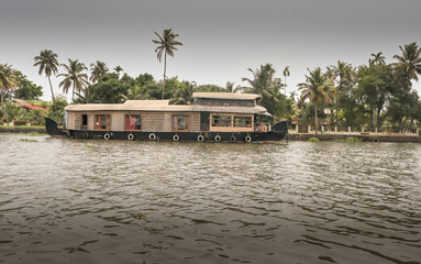 Obraz premium An Engaging picture of a Landscape scenery in the Kerala backwaters with a traditional Tour House boat visiting the Kochi city in India