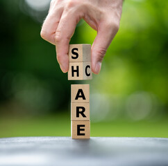 A stack of wooden cubes form the words care and share.