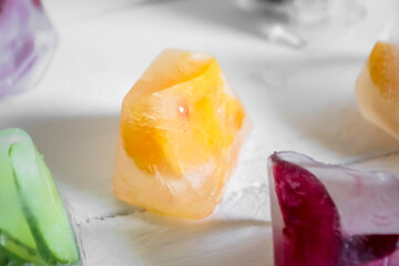 fruits and berries in ice. On a white background, ice cubes with fruit. years fruity in summer. Pieces of fruit in ice cubes.