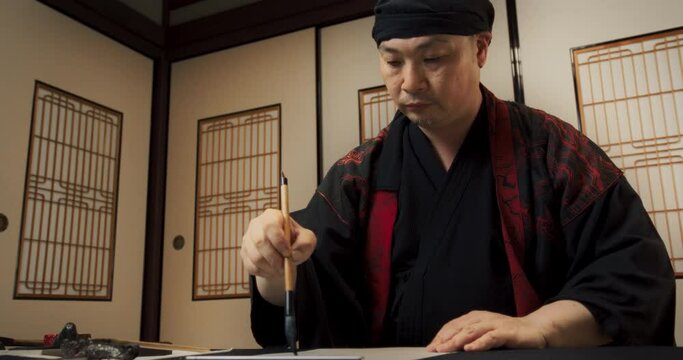 Portrait of a Japanese Calligrapher Working in Studio, Focused on Philosophical Process of Expressing Poetry, Literature and Painting Through the Ancient Art Form of Calligraphy. Low angle Static Shot