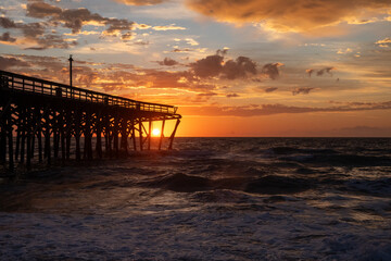 Fototapeta na wymiar Sunrise over the Pawley's Island fishing Pier one week after half the pier was destroyed by Hurricane Ian