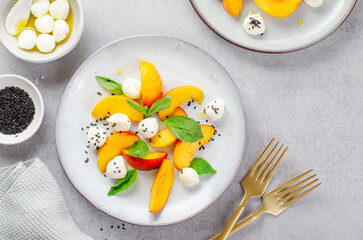 Grilled Peach Salad with Mozzarella Pearls on Bright Concrete Background