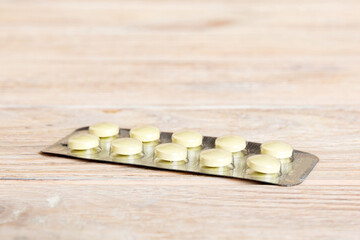 Fototapeta na wymiar Blister package with Vitamin on color background. Medicine pills on a light background. Medicines and prescription pills flat lay background. yellow medical tablets in blister