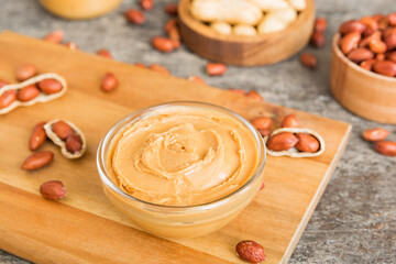Bowl of peanut butter and peanuts on table background. top view with copy space. Creamy peanut pasta in small bowl