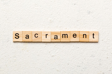 sacrament word written on wood block. sacrament text on table, concept