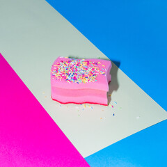 Pink sponge for dishes in the form of a birthday cake with sprinkles on colorful backgrounds. - 640221142