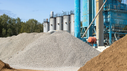 On the territory there is a pile of gravel and sand in close-up against the background of the...