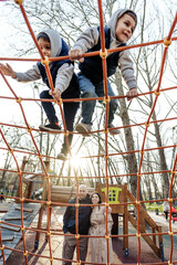 Two cute boys brothers playing on a playground outdoors