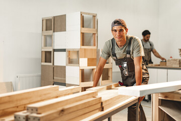 Portrait of young male carpenter standing in the wood workshop - obrazy, fototapety, plakaty