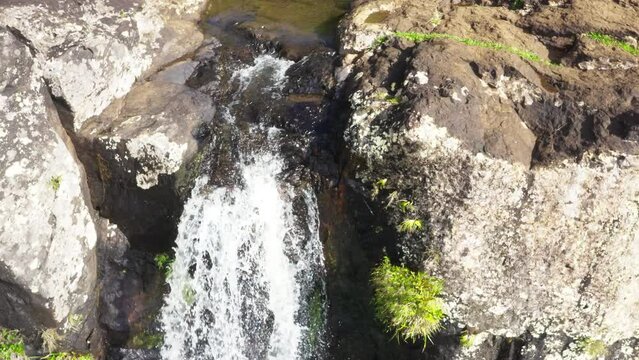 Picturesque flying over the mountain creek fall down from steep high cliff to wide valley. Cascade 500 Pieds waterfall on Mauricius island in Indian ocean.