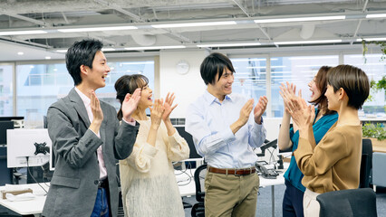 拍手するオフィスカジュアルを着た笑顔のビジネスグループ