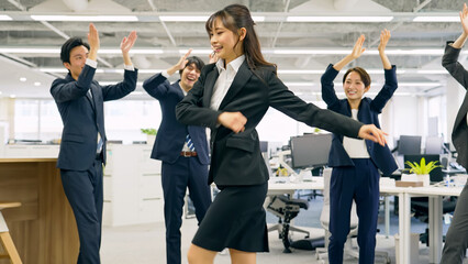 オフィスでダンスする会社員グループ