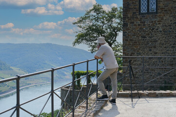 young man against backdrop of Sooneck Castle, tourist resting on observation deck, rest on route, concept romantic cruise on Rhine and Moselle