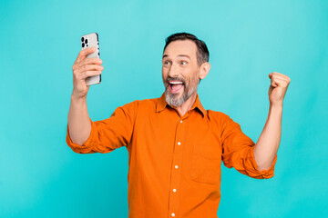 Photo of funny senior businessman brunet hair recording video phone selfie fist up holding phone...