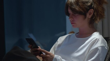 Beautiful pensive woman using phone, side view portrait scrolling and typing on mobile phone, digital technology for communication and network. Concept of online shopping or social media