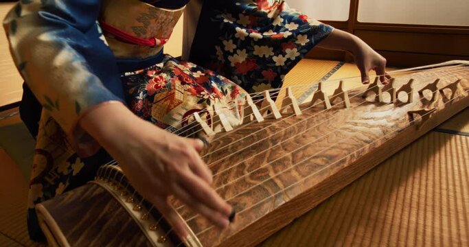 Close Up Footage of an Anonymous Female Playing a Traditional Japanese String Instrument. Focus on Hands of a Koto Musician, Performing Beautiful Intense Feudal Era Music on Stage