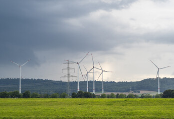 Fototapeta na wymiar wind turbine und green landscape in sunlight