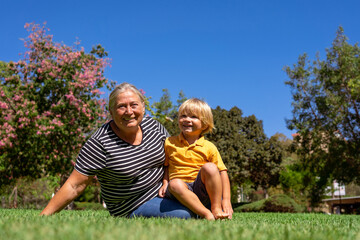 grandmother and grandson are walking in the park on a summer day