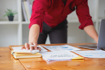 Business accounting concept, A businessman using a calculator with a computer laptop, budget, and loan paper in the office.