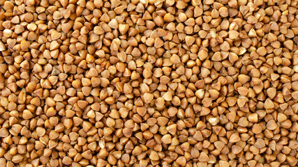 Buckwheat grains background, texture, top view. Dry grains of buckwheat, background, top view. Buckwheat kernel, background. Pile of buckwheat, background, texture, top view.