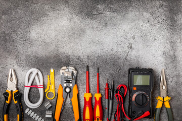 Electrician equipment on black textured background with copy space.Top view.Electrician tool set.Multimeter, tester,screwdrivers,cutters,duct tape,lamps,tape measure and wires.Flet lay.Concept buildin © Avocado_studio